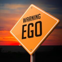 EGO on Warning Road Sign on Sunset Sky Background.